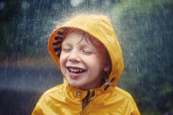 Happy smiling little boy in the rain