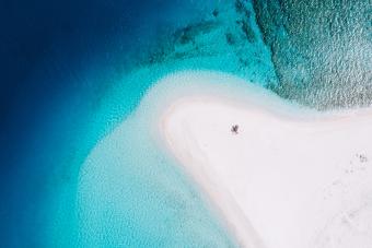 White sandbar with clear blue tropical water from above