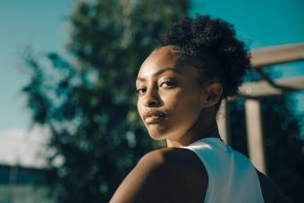 Portrait of athlete looking over shoulder on sunny day