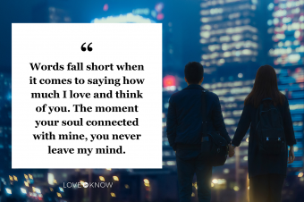 Couple holding hands against illuminated urban cityscape at night