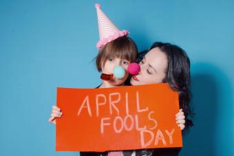 Mother with her daughter holding an April Fool's sign