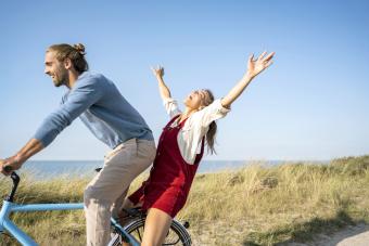 Man and woman enjoying bicycle ride against clear sky