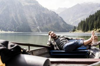 Relaxed man in boat on mountain lake