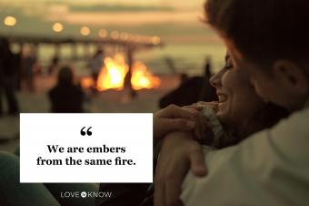 romantic couple at bonfire on beach