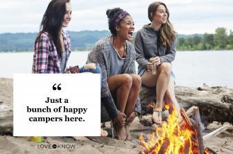 three friends women laughing having fun at campfire