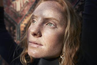 Woman with green eyes looking away in sunlight