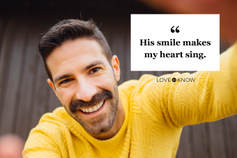 Smiling man with mustache in yellow sweater taking selfie
