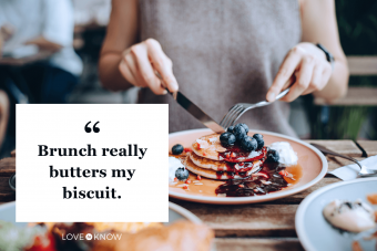 young woman sitting at dining table eating pancakes with blueberries