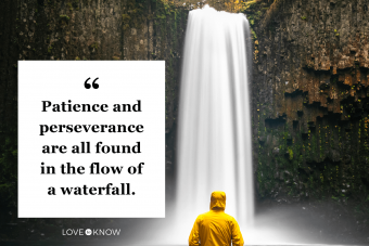 Man with yellow jacket standing gazing at the waterfall