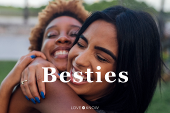 Two happy female friends hugging in a park