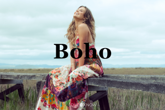 Young woman in boho maxi dress sitting on elevated wooden walkway