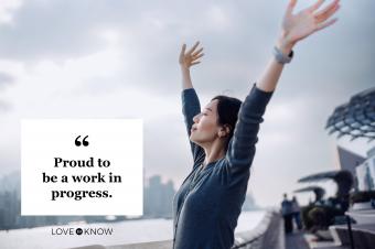 woman with hands up facing sky