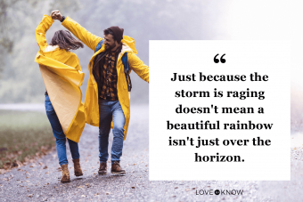 Happy couple having fun while dancing on a rain