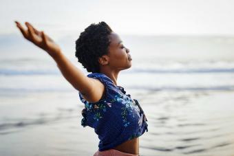 woman with arms outstretched feeling free at beach