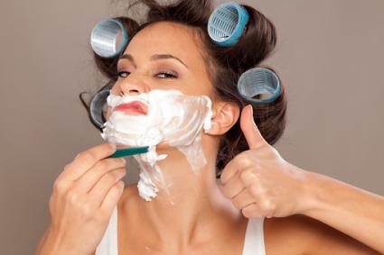Woman in curlers shaving face