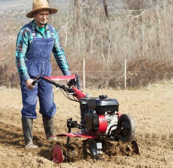 Man cultivates the land with the cultivator