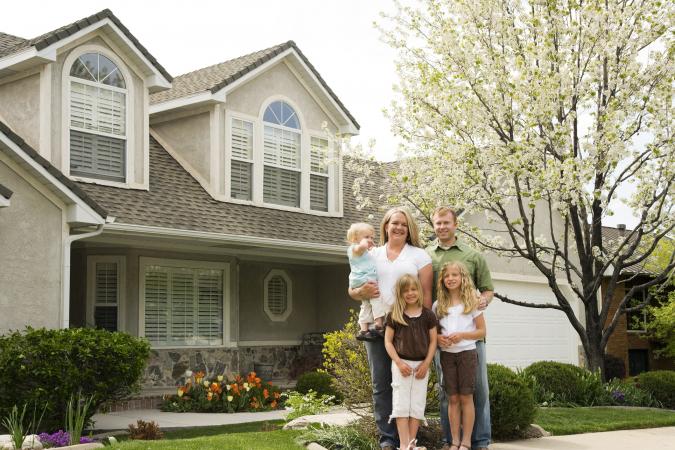 Family of five at home in front of white flower tree