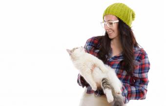 Mujer sonriendo mientras sostiene un lindo gato