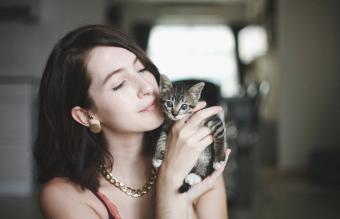 Mujer con un lindo gatito en la mano
