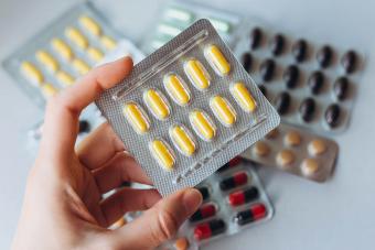 hand holds a package of yellow pills
