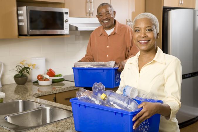 Couple in kitchen with recycling bins