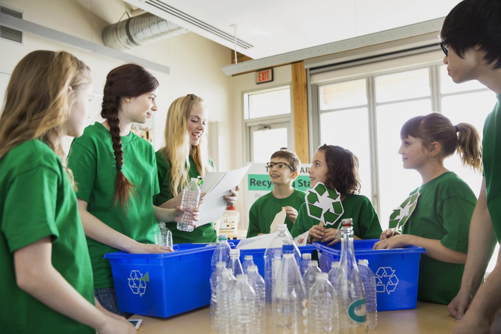Mentor teaching students to recycle in classroom