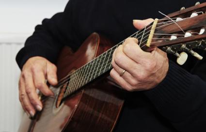 Man strumming a guitar chord