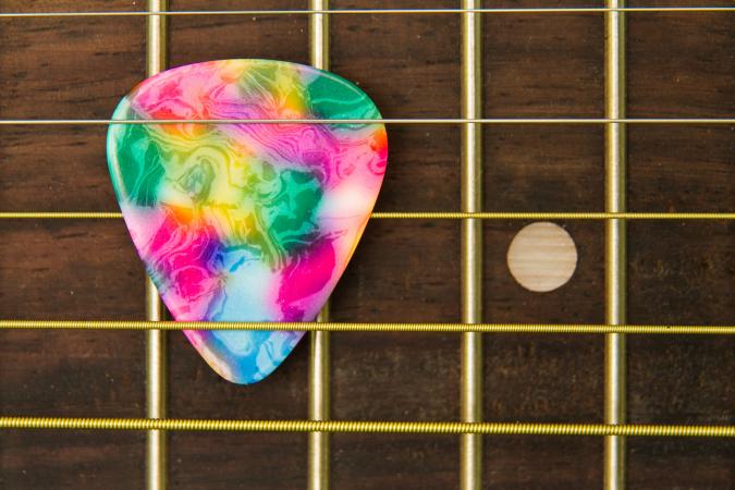 Close-Up Of Guitar With Colorful Pick