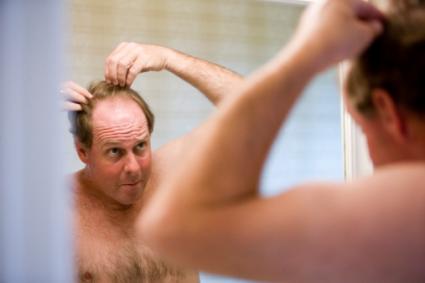 Mature man looking in bathroom mirror