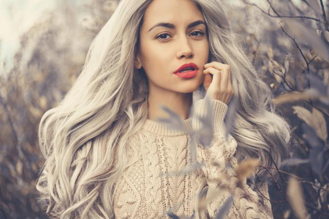 Beautiful lady surrounded by autumn leaves