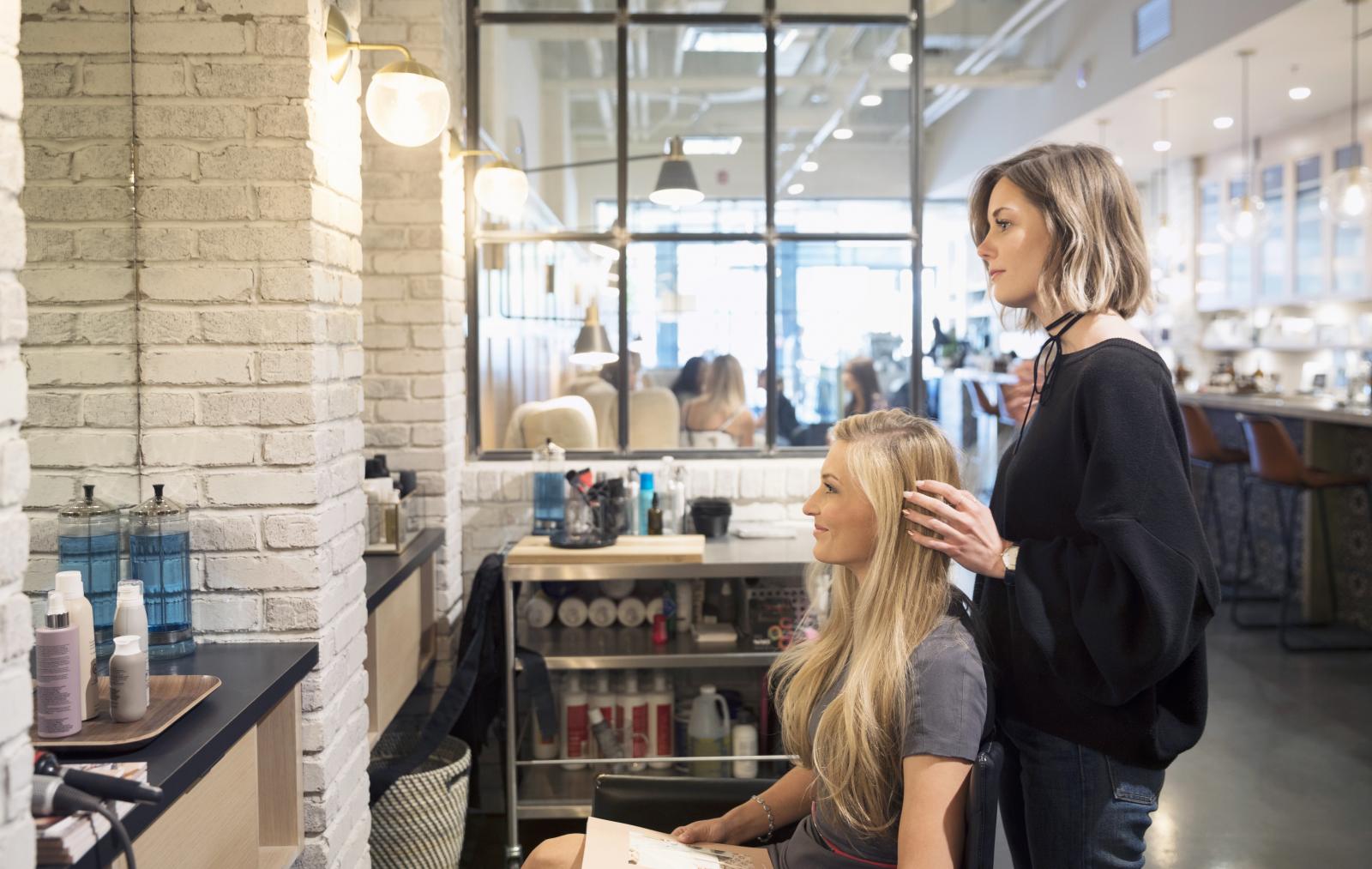 Female hair stylist and customer talking
