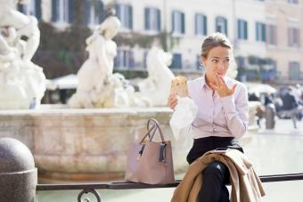 Businesswoman sitting next to beige purse on her lunch break 