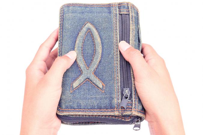 Hands holding denim clutch with monogram
