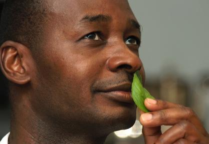 A man enjoying the scent of basil.