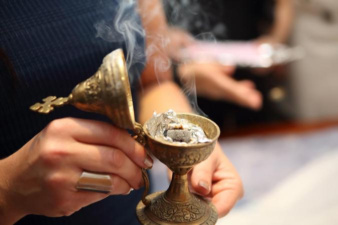 Woman holding incense burner with incense