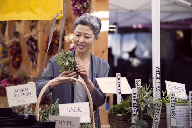 Woman at market buying herbs