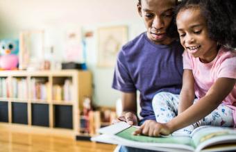 father and daughter reading at home