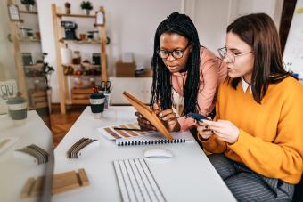 Friends discussing over digital tablet at desk