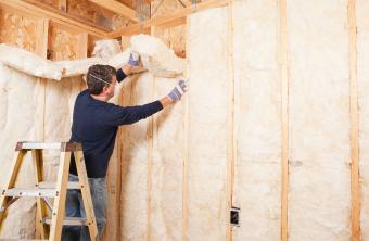 Man insulating wall with fiberglass batt