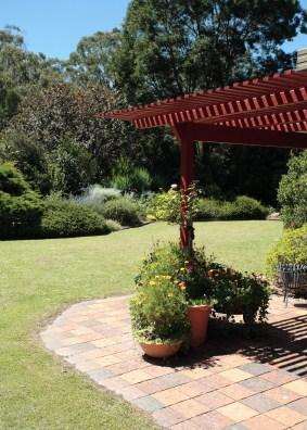 An arbor provides shade to a patio.