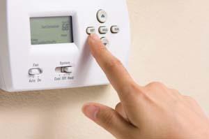 Hand programming a low-voltage thermostat.