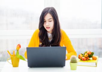 Girl wearing yellow sitting with laptop