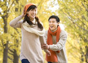 Young Couple Playing in a Park in Autumn