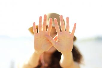 Young woman reaching hands in front of face