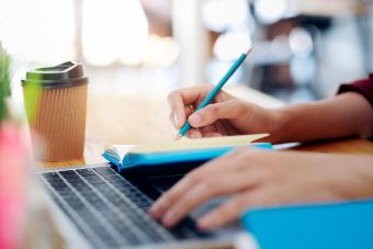 Close up female hands with pen writing on notebook