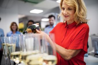Smiling businesswoman pouring champagne in flute