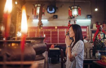 Woman praying in a Chinese temple