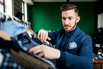 Man in a suit organizing his closet