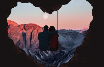 Couple on swing contemplating the mountains