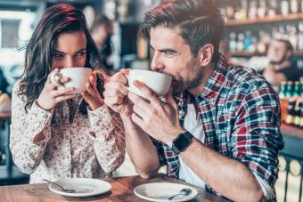 Young couple drinking coffee and looking each other